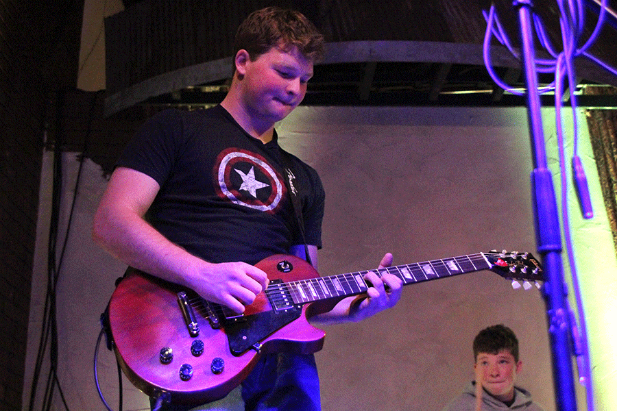 Freeman plays a note on electric guitar.