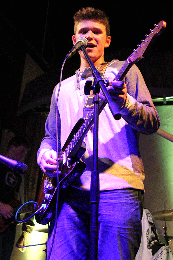 Walsh sings as he plays a note on electric guitar.