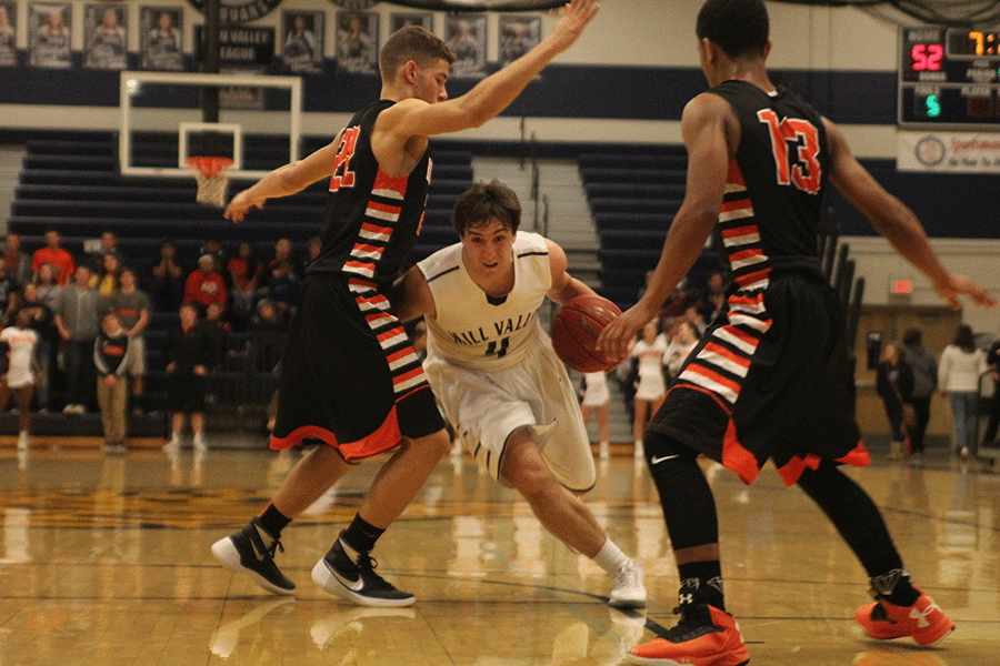 Senior Logan Koch runs down the court while dribbling the ball.