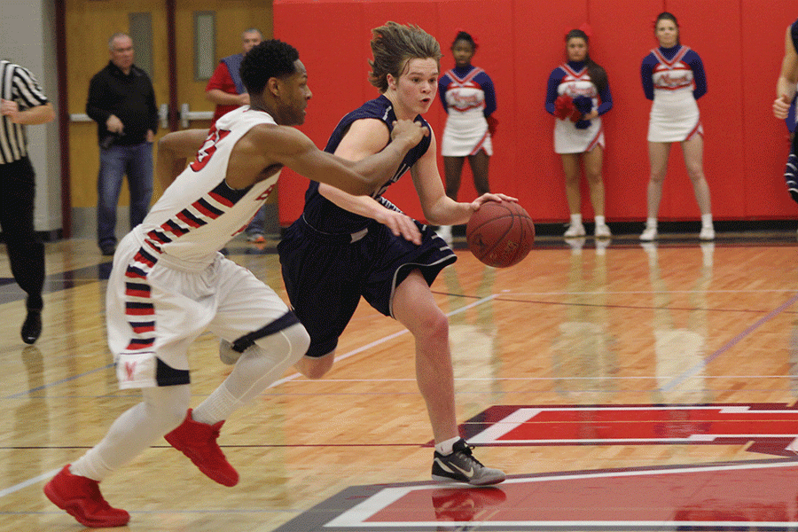 Dribbling the basketball, sophomore Cooper Kaifes sprints down the court.