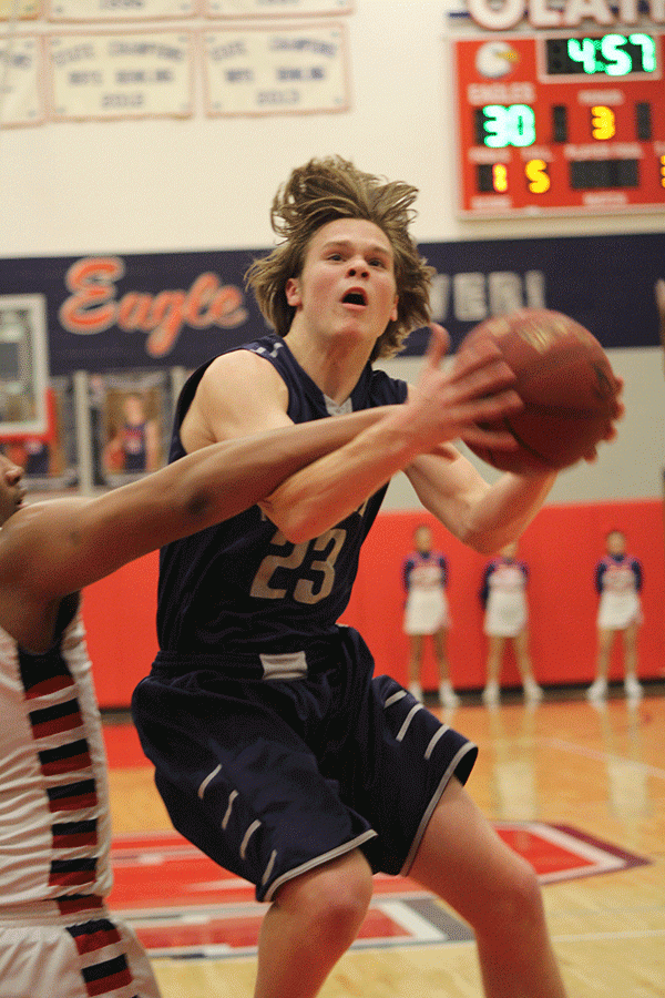 Sophomore Cooper Kaifes jumps to make a basket through an opponents block.