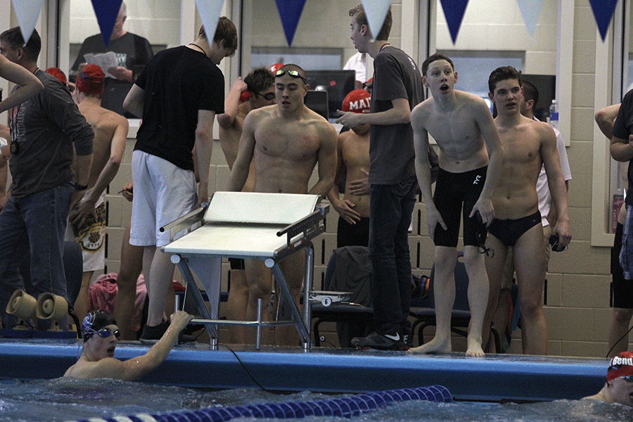 After the 200 meter freestyle relay, freshman Chris Sprenger looks toward the scoreboard with his teammates to check their time and place.