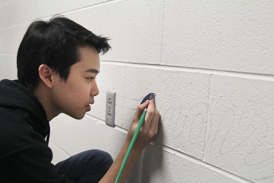 Sophomore Simon Vongxay  continues to paints the C-wing mural on Thursday, Feb. 18. 