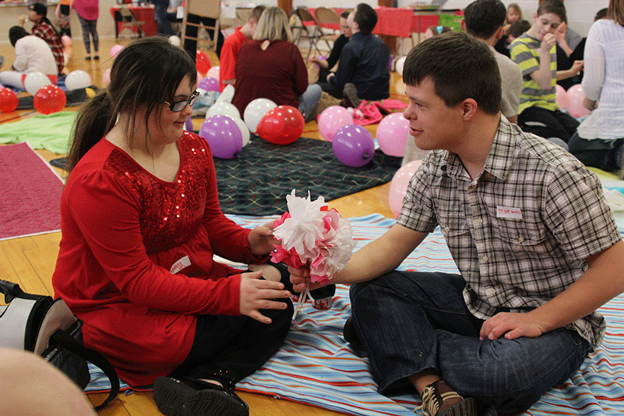 At the prom hosted by the special education department on Friday, Feb. 19, freshman Matt Santaularia hands a bouquet of hand-made flowers to his friend.