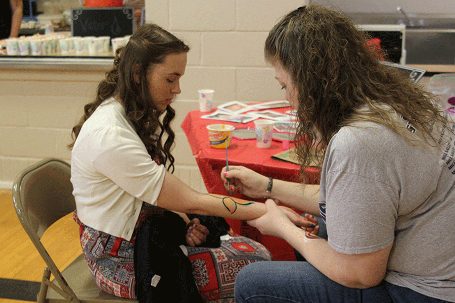 Special education teacher Pam Sheehan does face paint for the students at the prom.