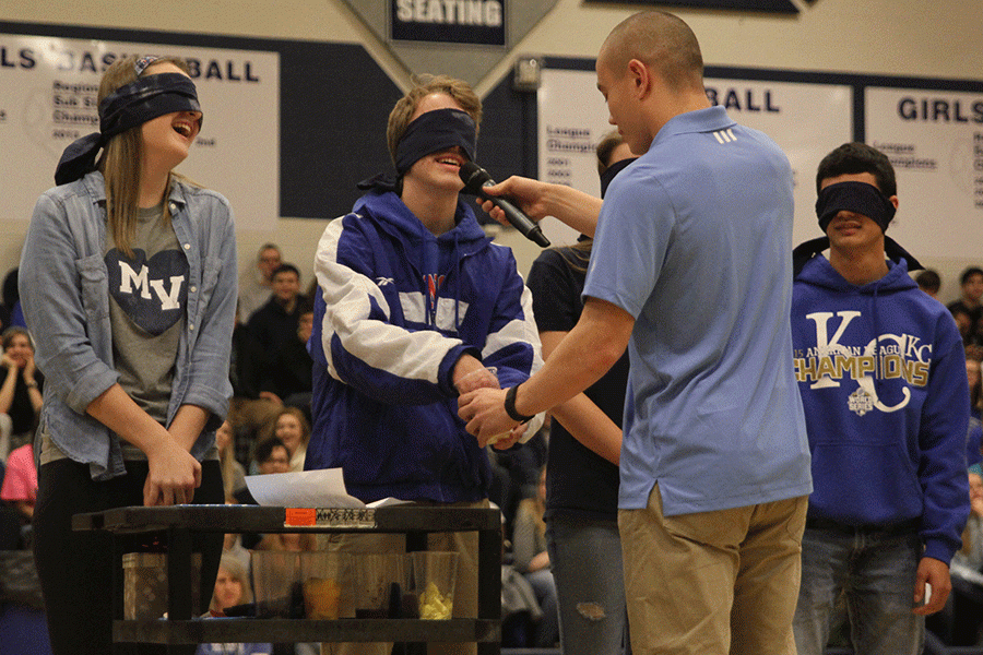 Homecoming King candidate Shane Calkins wears a blindfold and stuffs his hand into a cup full of yogurt as he tries to guess what it is.