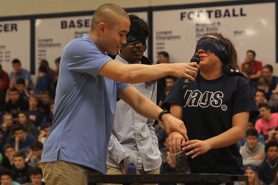 Blindfolded Homecoming Queen candidate Marisa Macias fears whats waiting in the cup for her to identify during the Winter Homecoming pep assembly.