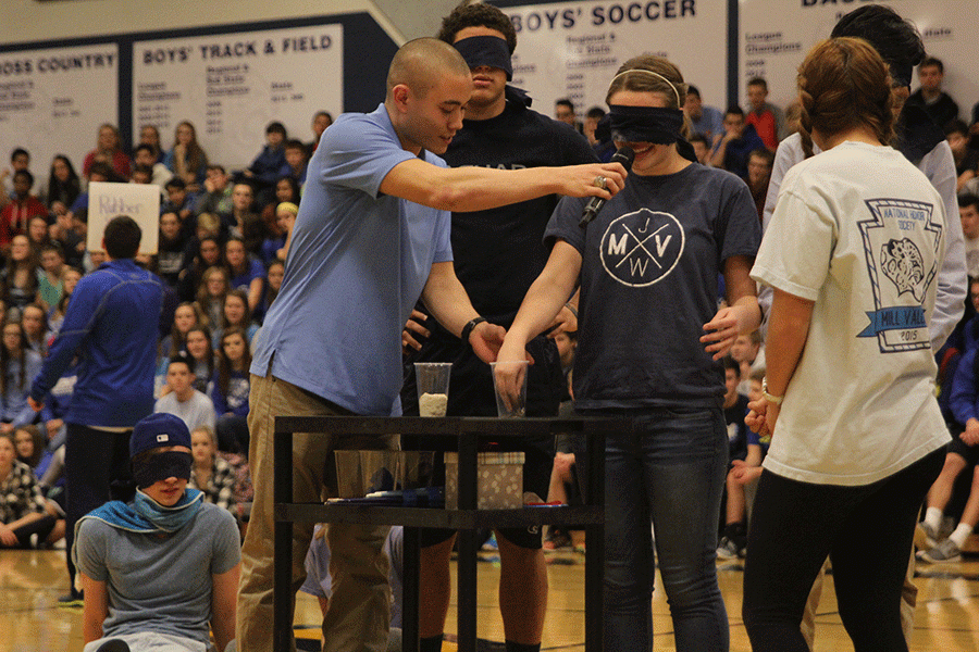 Blindfolded Homecoming Queen candidate Sarah Myers attempts to identify the mysterious object(s) in her cup during the Winter Homecoming pep assembly.