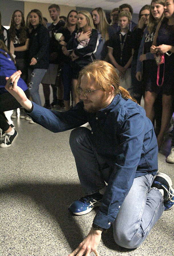 Crouching down, senior Will McFarlin challenges students around him to a dance battle.