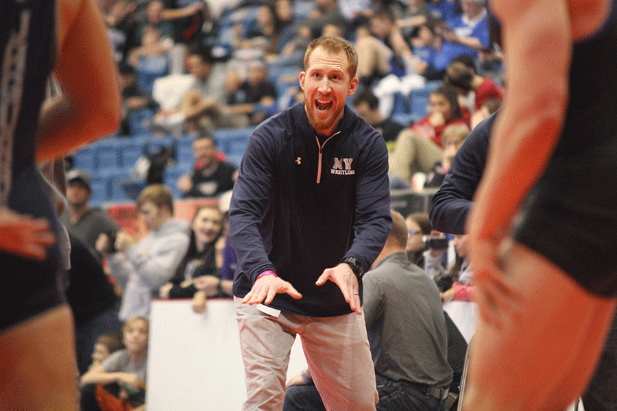 In the middle of the match, assistant coach Andrew Hudgins gives advice to his wrestler.