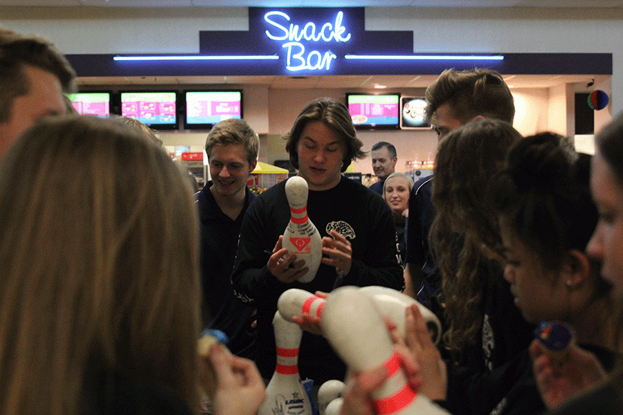 Senior Tyler Shurley signs a teammates bowling pin.