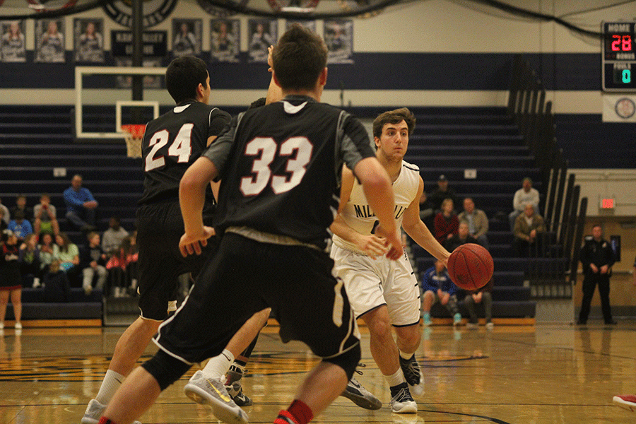 Looking to an open teammate, senior Logan Koch starts to run a play. The jaguars defeated the Bishop Ward Cyclones 60-28 on Friday, Feb. 5.