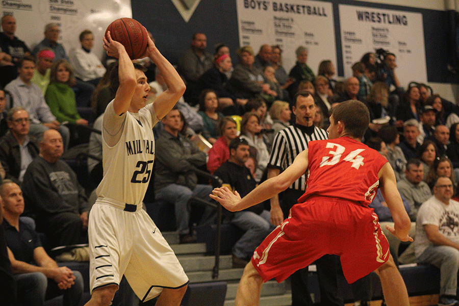 Looking for an open teammate, senior Jaison Widmer holds the ball away from his defender.