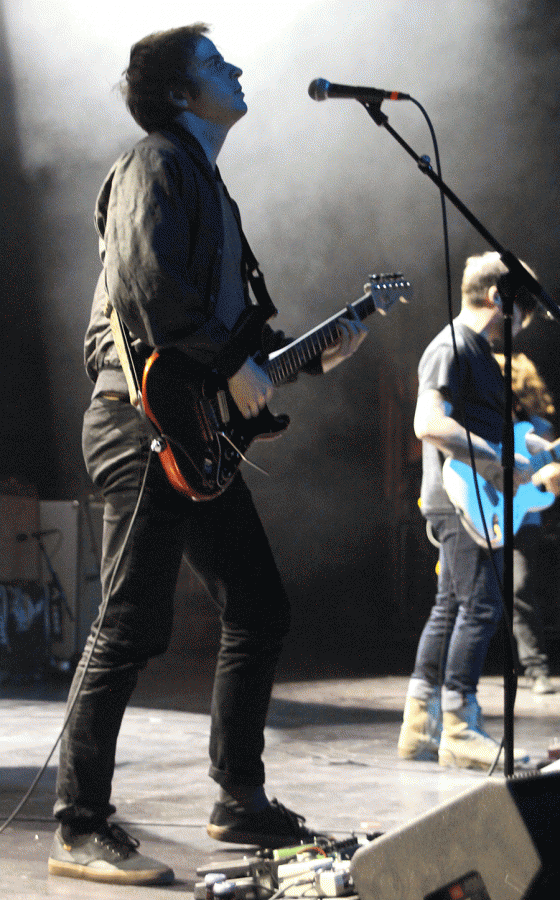 Wavves guitarist-vocalist Alex Gates performs, silhouetted by white lights.