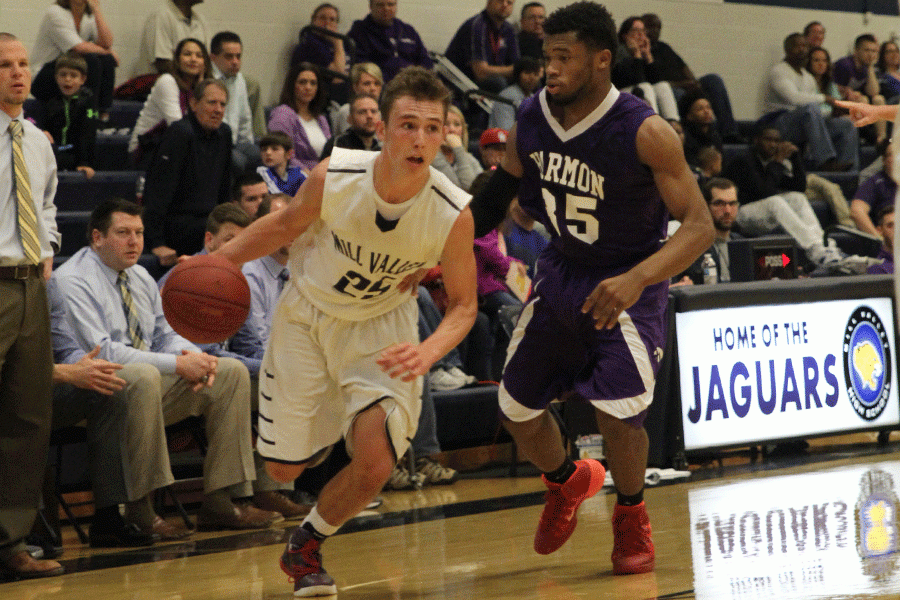 Dribbling the ball down the court during the sub-state boys basketball game against Harmon Hawks on Friday, March 4, senior Jaison Widmer looks for an opening to score.