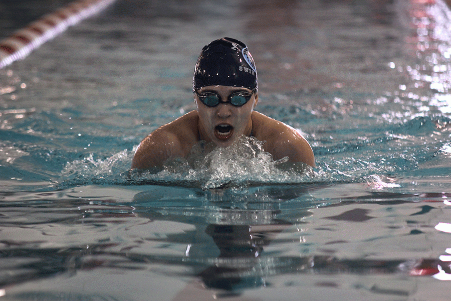 Swimming in the 100 yard breaststroke, junior Vicki Robinson comes up for air.