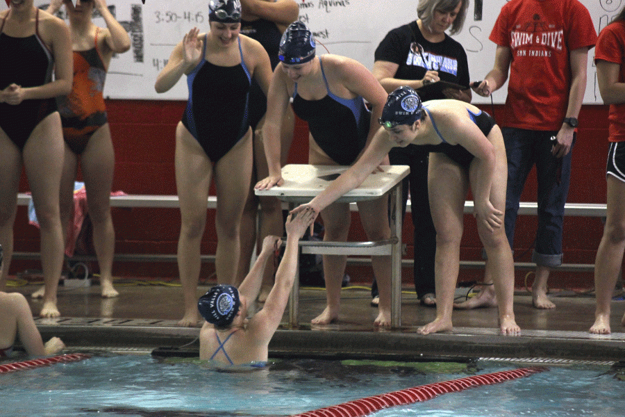 After placing first in the 200 yard freestyle relay, sophomore Jaz Schwegman high fives teammate Vigneulle Puliatti.