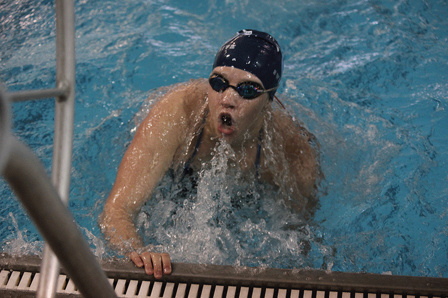 Pushing off the edge of the pool, freshman Celia Kistner competes in the butterfly.