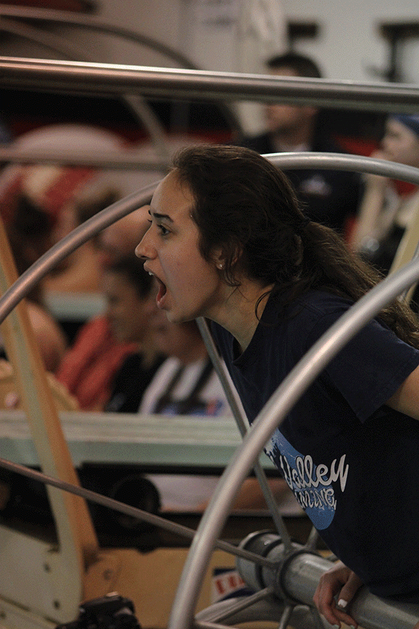 Junior Alexis Medina cheers on swimmers as part of her role as a manager.