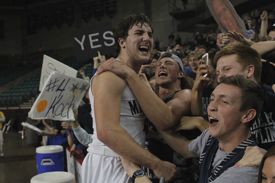 Senior Logan Koch jumps into the student section to celebrate a state championship win.