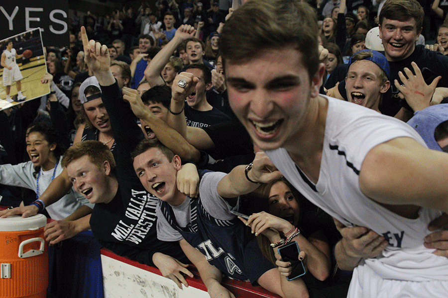 The student section celebrates with senior Ethan Lane.