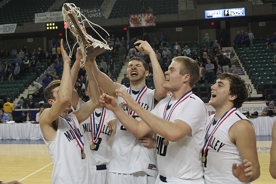 Senior basketball players hold up the trophy in celebration.
