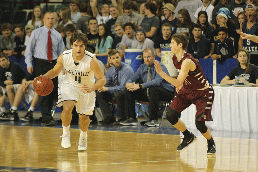 Senior point guard Logan Koch dribbles down the court.