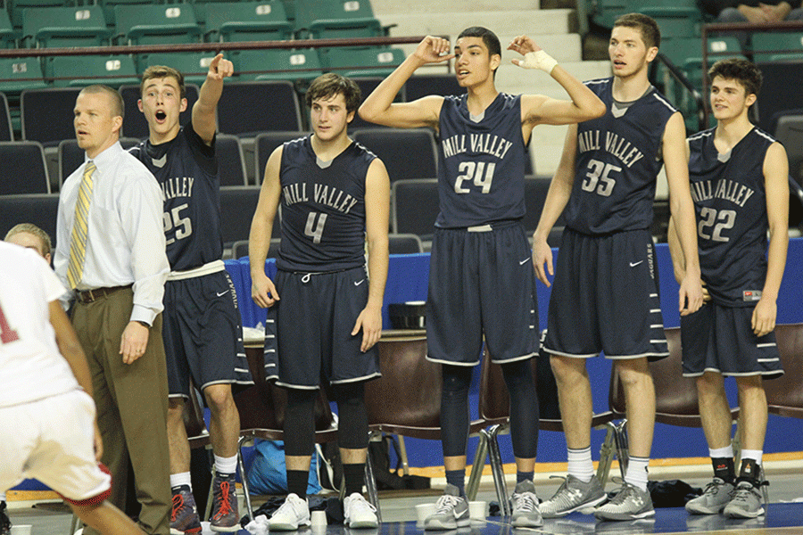 Waiting for the buzzer to hit zero, the basketball team helps coach their teammates.