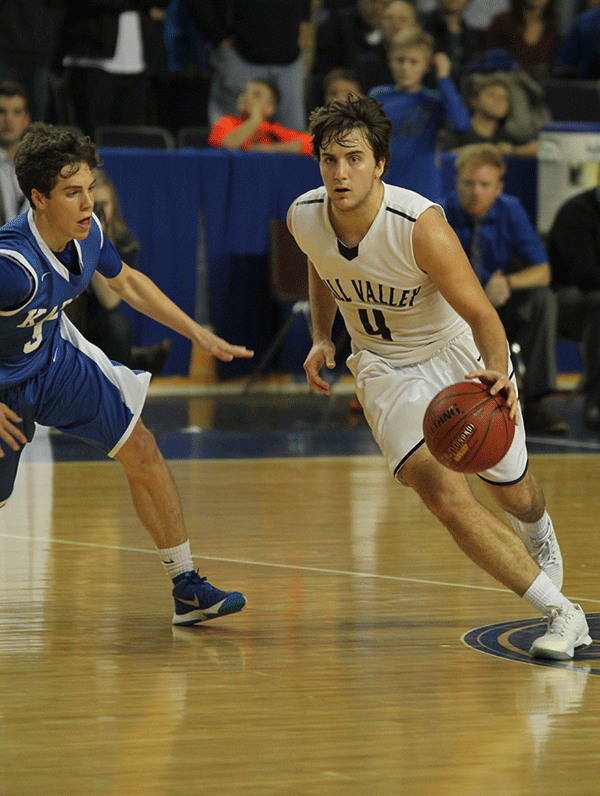 Looking for an open teammate, senior Logan Koch dribbles the ball.