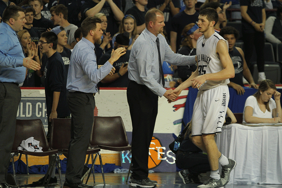 Making his way off the court, senior Clayton Holmberg shakes hands with the coaching staff.