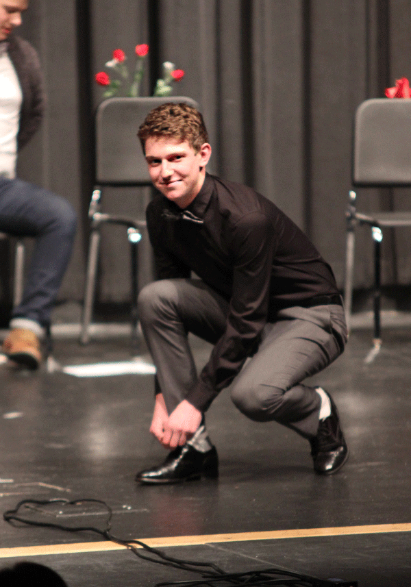 As senior Garret Fields ties his shoes, he flashes a pose.