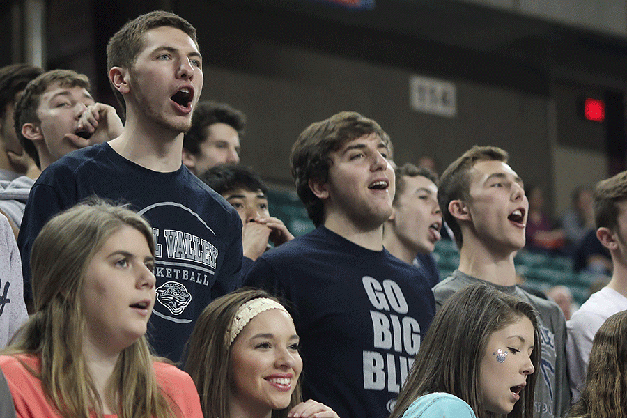 Senior boys basketball players Clayton Holmberg, Logan Koch and Jaison Widmer cheer on the girls team with the rest of the student section as they compete against Salina Central.