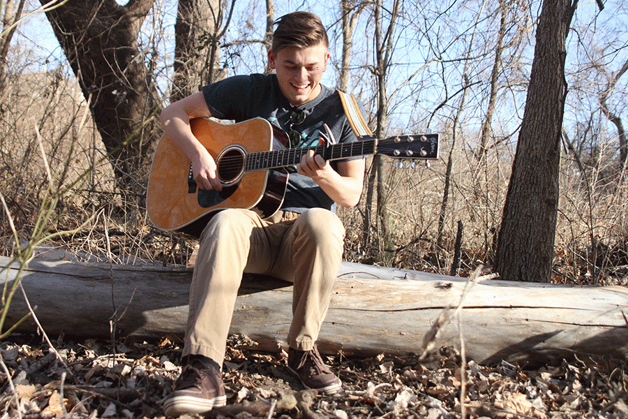 In the woods, junior Brady Herron plays his guitar on Monday, Feb. 29. 