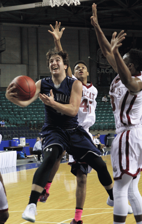 Blocking out his opponents, senior Logan Koch jumps to shoot.