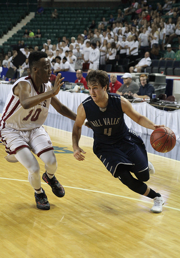 Rushing past his opponent, senior Logan Koch dribbles towards the basket.