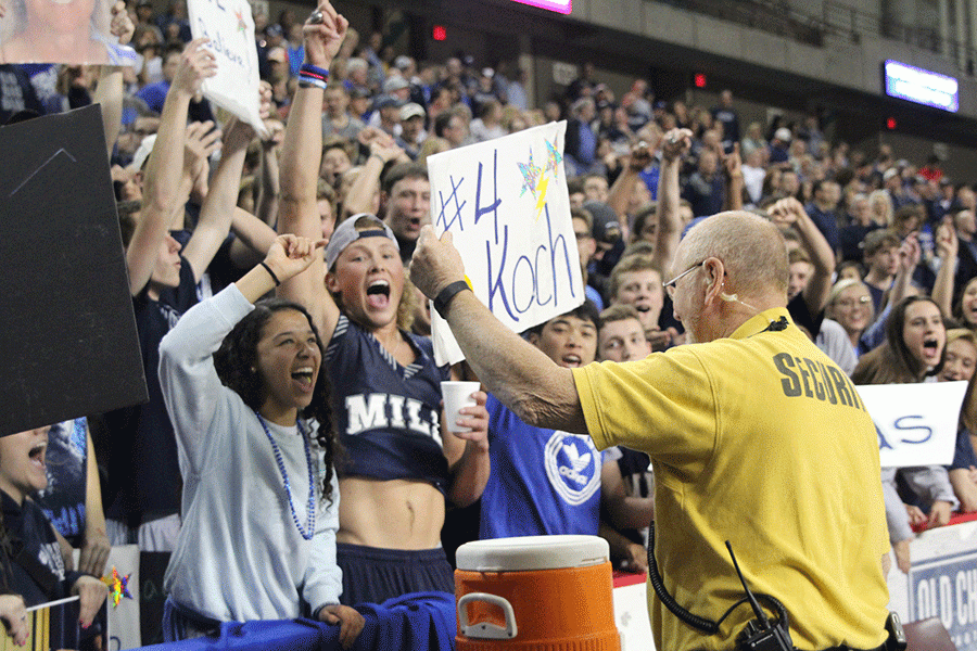 After a sign falls out of the stands, a security guard holds up the sign before returning it to the crowd.