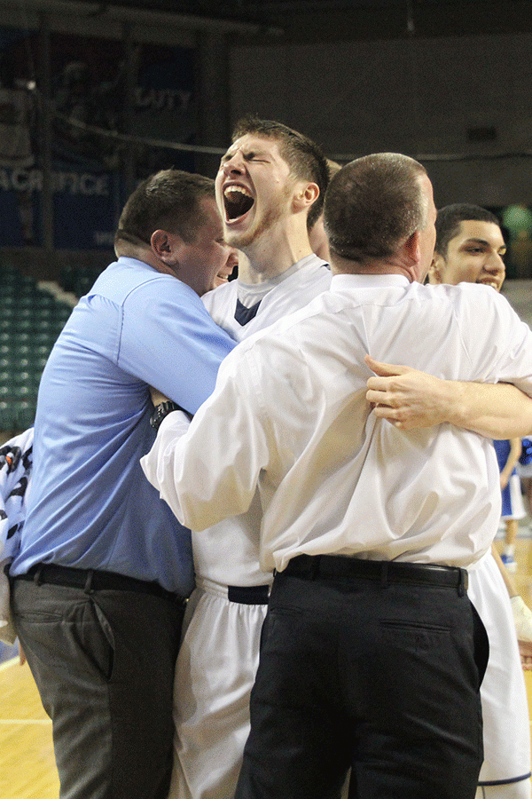 Senior Clayton Holmberg hugs head coach Mike Bennett and assistant coach Alex Houlton after the game.