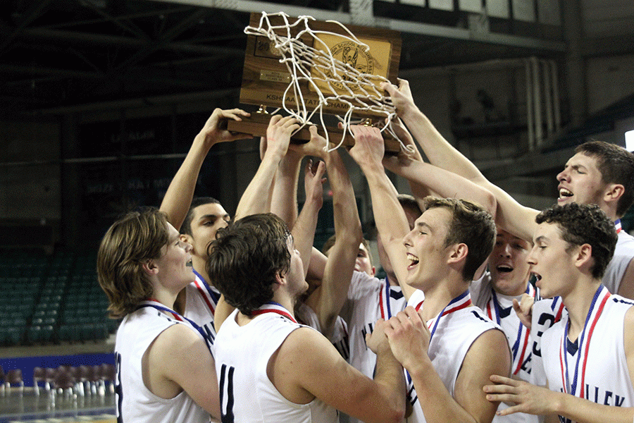 After winning the state championship game, members of the team hold up their trophy.