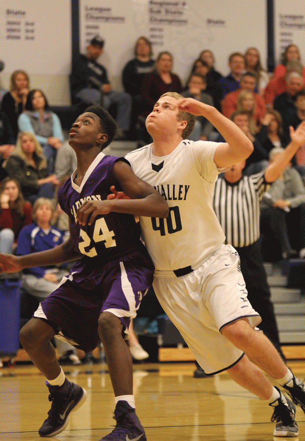 Senior Tyler Grauer, blocks his opponent from rebounding the basketball.