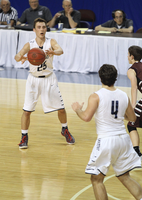 Looking for an open team member, senior Jaison Widmer passes to senior Logan Koch.