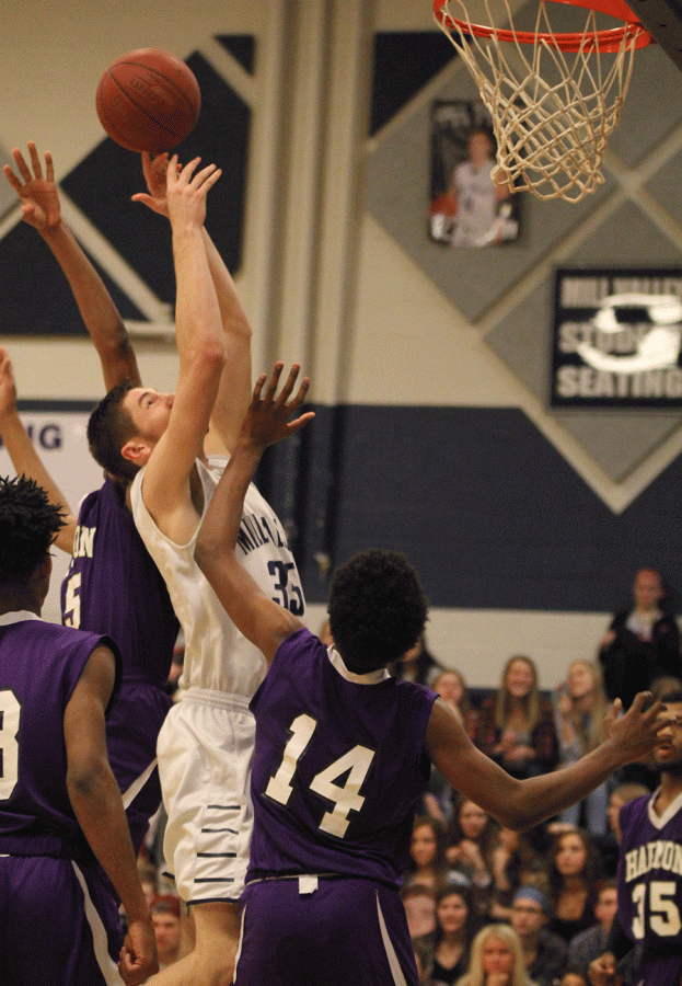 Senior Clayton Holmberg reaches up to rebound the ball.