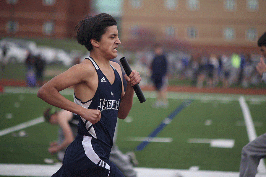 Senior Michael Snyder runs with the baton during the boys 4x800 relay.