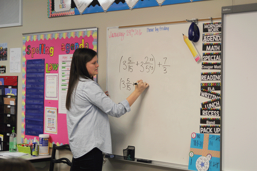 Writing on her whiteboard, 2010 graduate Katie Maybell teaches her 5th grade class. 