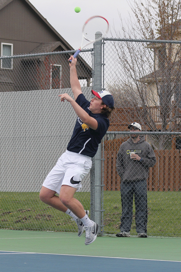 Jumping for the ball, senior Tyler Shurley attempts to return the ball back over the net. 