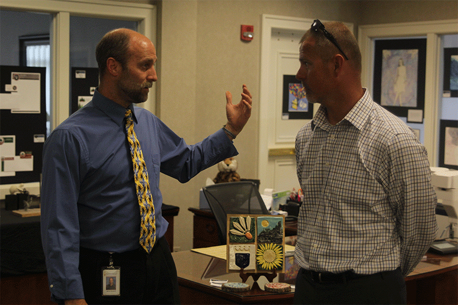 During the first day of the art show on Monday, April 25, art teacher Jerry Howard and athletic director Jerald VanRheen converse over the art displayed.