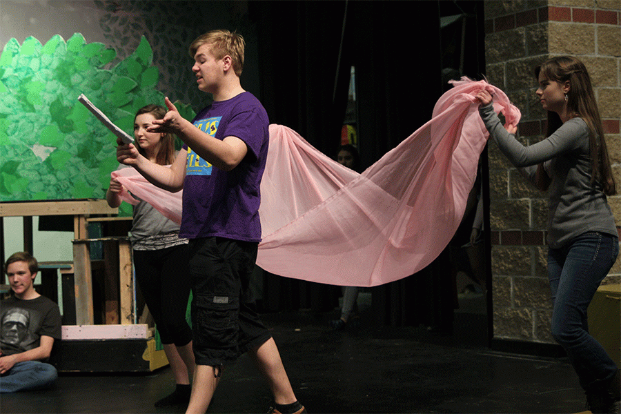 Playing the role of a fairy, senior Maria Guilford (right), directs senior Carson Vitt to his resting place during rehearsal on Thursday, March 31.