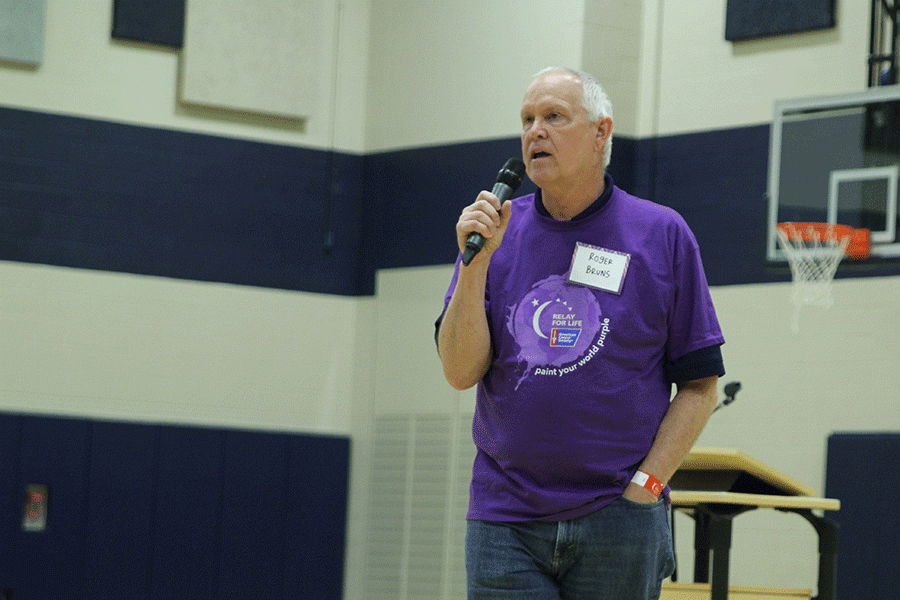 Retired teacher Roger Bruns speaks to the crowd during the opening ceremony. 