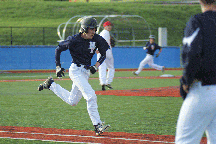 After hitting the ball, senior Clay McGraw runs towards first base.