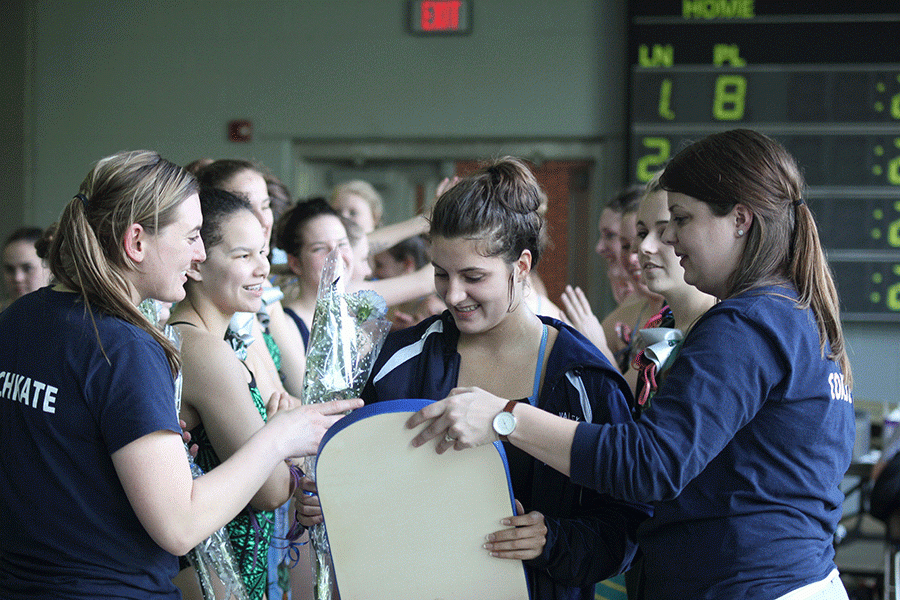 Senior Claudia Meredith receives her kick-board that was signed by the team.