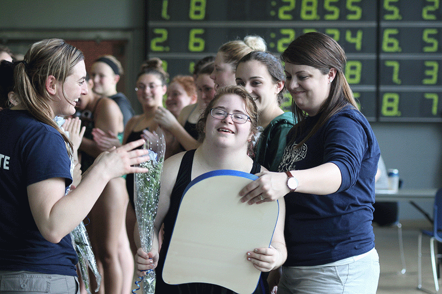 Smiling happily, senior Sara Pietig accepts her gifts from the coaches.